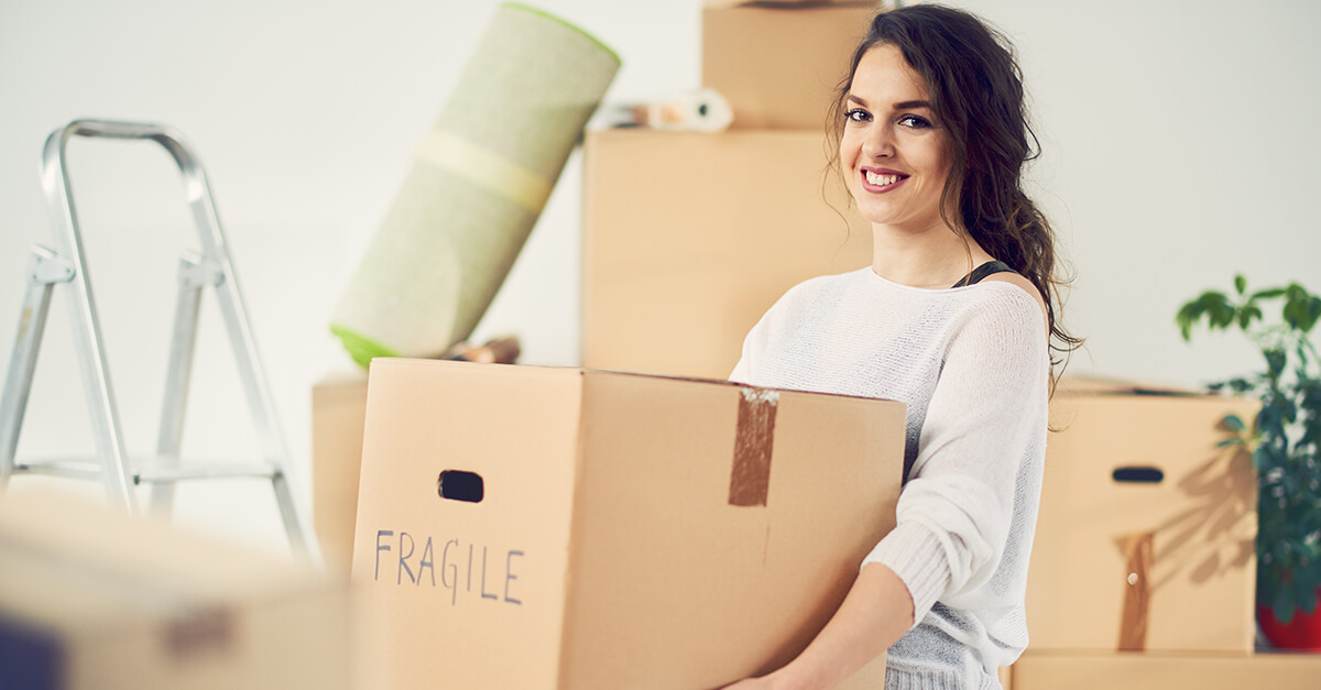 En person bär en kartong