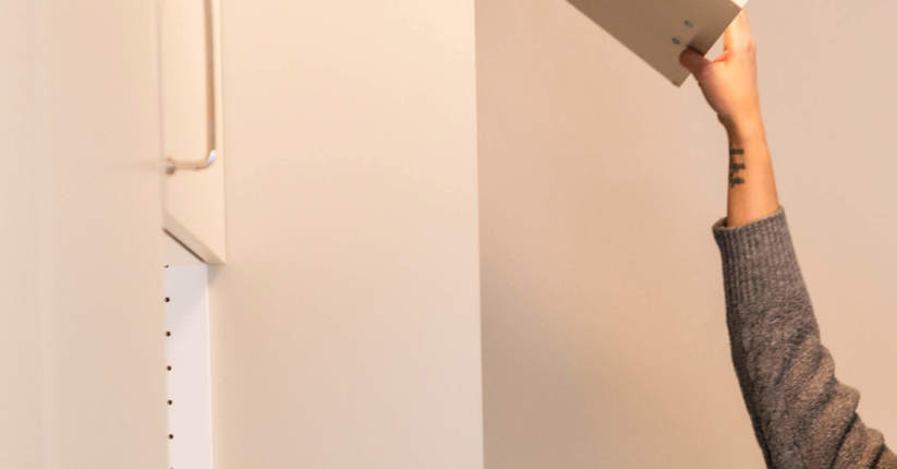 Hand öppnar ett skåp