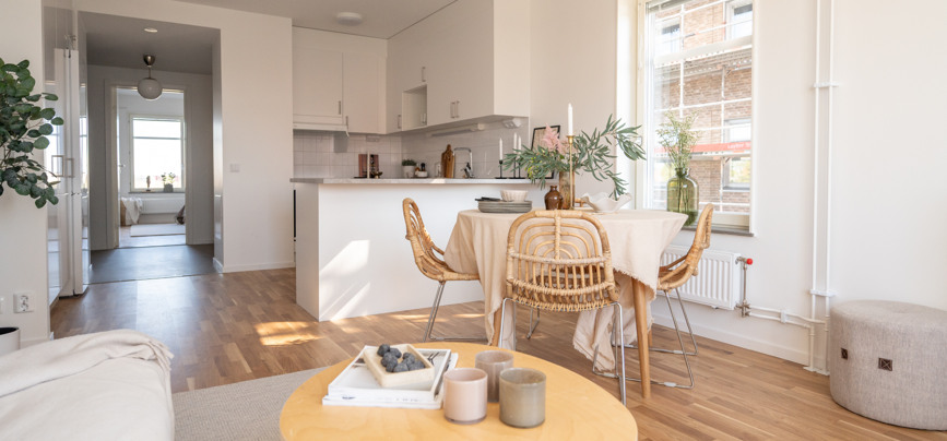 Ett vardagsrum fyllt med möbler och ett kök.