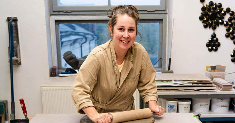 Ylva W. Franzén står vid ett bord med kavel i handen